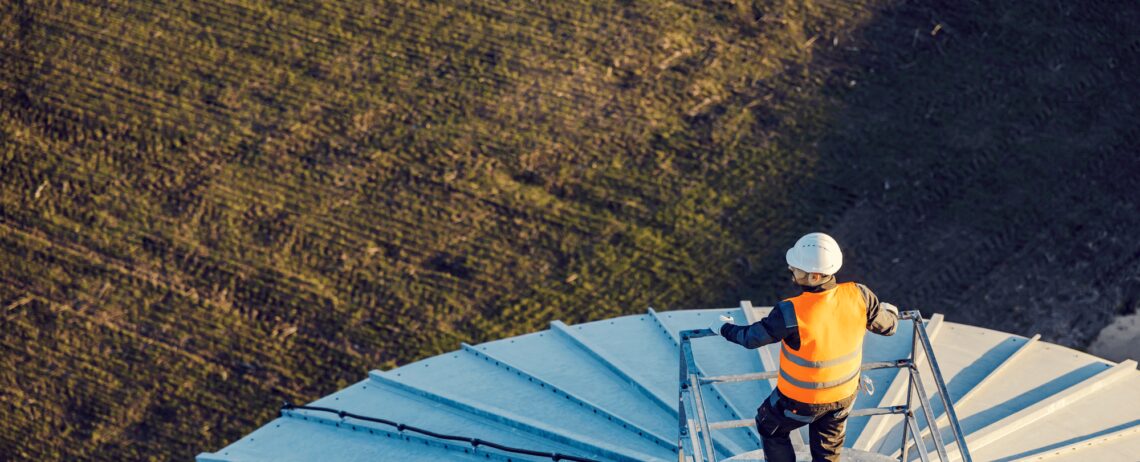 Aerial view of an industry worker standing on top of the silo.